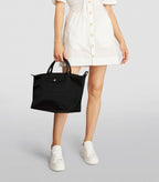Longchamp Le Pliage Energy L handbag in black with sleek, folded design and sturdy handles, displayed on a plain background.
