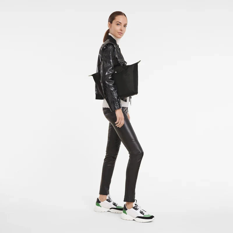 Longchamp Le Pliage Green M Tote bag in black, showing the foldable fabric bag with leather handles and logo detail.