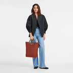 Longchamp Le Pliage Green M Tote bag with vertical Chestnut accents, showcasing its structured design and durable material.