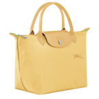 Longchamp Le Pliage Green S handbag in wheat color, showcasing the compact, foldable leather bag with handles and subtle branding.