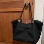 Longchamp Le Pliage Original M Tote Bag in black, showing its sleek design and durable fabric on a neutral background.