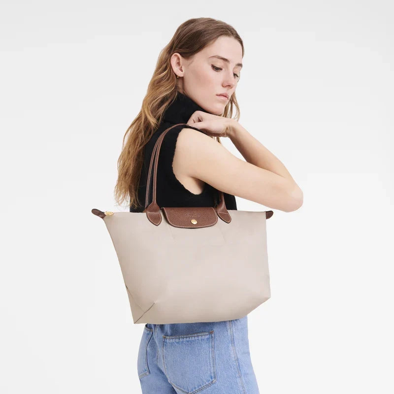Longchamp Le Pliage Original M Tote Bag in wine-colored paper with handles, showcasing its lightweight and foldable design.
