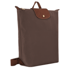 Longchamp Le Pliage Original M backpack in beige fabric with leather straps and handle, showing front view and foldable design.