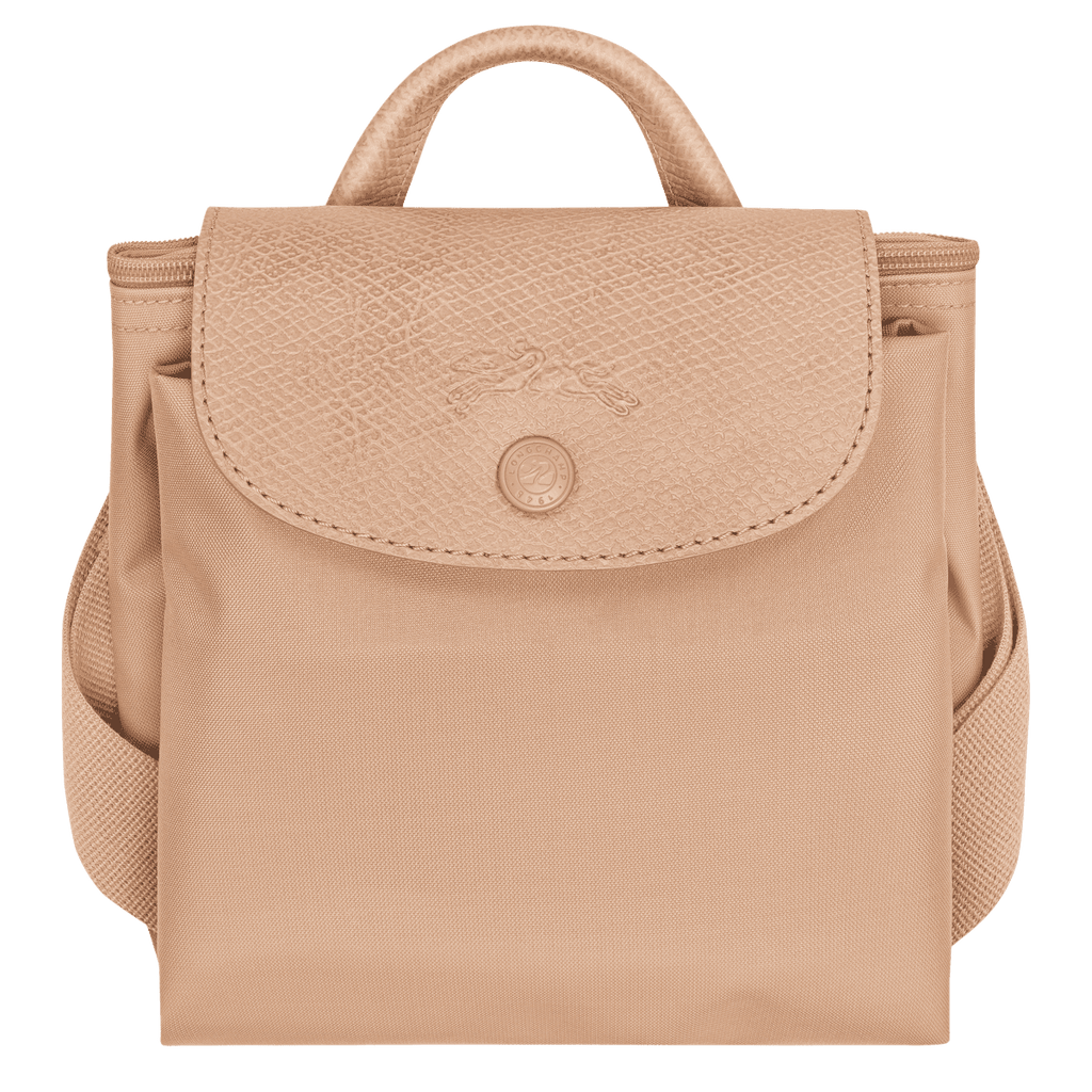 Longchamp Le Pliage One M backpack showing its beige nylon exterior with leather handles and compact, foldable design.