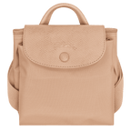 Longchamp Le Pliage One M backpack showing its beige nylon exterior with leather handles and compact, foldable design.